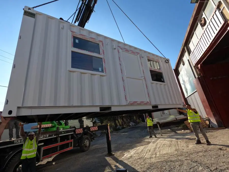 Container lifted by crane onto a truck